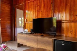 a flat screen tv sitting on top of a wooden wall at La Vela Legacy Resort in Thôn Dương Xuân Hạ