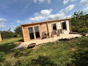 a small cabin with two chairs on a deck at Buzzard Holt Hosting in Buckingham