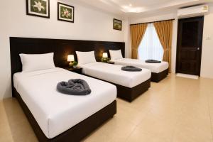 two beds in a hotel room with towels on them at Hill Side Patong in Patong Beach +28 photos