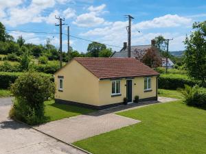 a small yellow house with a red roof at Crossways in Wells