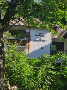 a building with a sign that reads honours gardenagency at Haus Goldregen - App. 223 in Thalfang