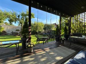 a porch with swings and a table and chairs at Mooni Cottage in Pärnu