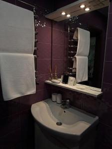 a bathroom with a sink and a mirror and towels at Затишні апартаменти Східна Перлина in Vinnytsya