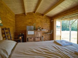 a bedroom with a bed in a wooden cabin at Simple Basketmakers Hut Cabin for Two in Chiddingstone