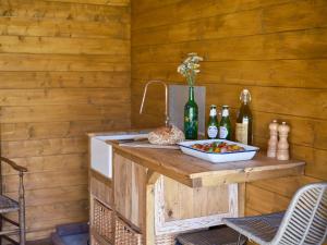 a kitchen with a counter with a sink and bottles at Simple Basketmakers Hut Cabin for Two in Chiddingstone