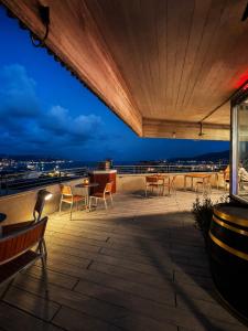 a rooftop deck with chairs and tables at night at Allegroitalia La Spezia 5 Terre in La Spezia