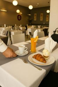 ein Tisch mit einem Teller Croissants und einer Tasse Kaffee in der Unterkunft Hotel Zenith in Oran