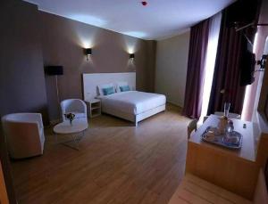 ein Hotelzimmer mit Bett, Tisch und Stühlen in der Unterkunft Hotel Zenith in Oran + 2 Fotos