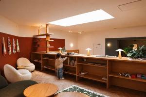 a young boy standing in a living room with a desk at Maison Arya in Brussels