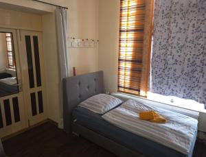 a small bed in a bedroom with a window at EG Ferien- und Monteurwohnung mit AC in Osterburg Siedlung