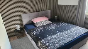 a bed with a blue comforter and a pink pillow at Ferien-, Monteurswohnung in Bottrop in Bottrop