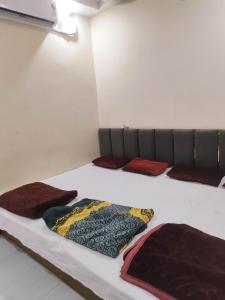 a bed with three pillows on it in a room at SHRI VIJAYVEER PALACE in Ujjain +26 photos
