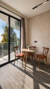 a dining room with a table and chairs and a window at Kobuleti Lounge in Kobuleti