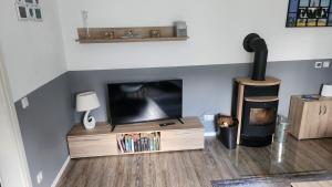 a living room with a flat screen tv and a wooden entertainment center at Ferien-, Monteurswohnung in Bottrop in Bottrop
