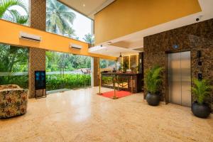 an open lobby with palm trees and an elevator at Summit Calangute Resort & Spa in Calangute +43 photos