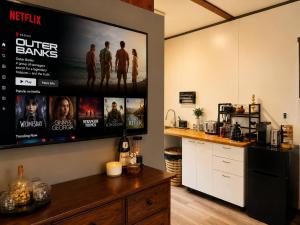 a kitchen with a large tv on the wall at Willow Cabin at The Reset Retreat in Charbon