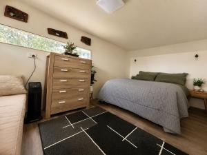 a bedroom with a bed and a dresser at Willow Cabin at The Reset Retreat in Charbon +2 photos