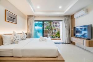a bedroom with a large white bed and a large window at Westkey Patong Hotel in Patong Beach +49 photos