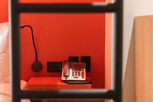 a desk with a phone on a red wall at Best Western Insadong Hotel in Seoul