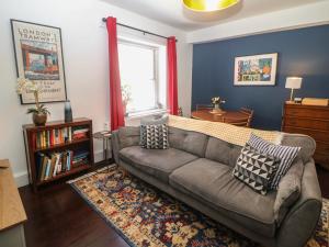 a living room with a couch and a window at Cosy Cottage in Buxton