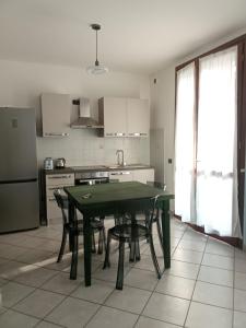 a kitchen with a green table and chairs in it at Via Roma OttantaDue in Valmadrera