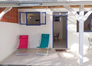 two colorful chairs sitting in a room at Appartement cosy Le Marin 60 m² + jardin in Le Marin