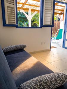 a room with a couch and two windows at Appartement cosy Le Marin 60 m² + jardin in Le Marin