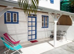 a patio with chairs and a table and a house at Appartement cosy Le Marin 60 m² + jardin in Le Marin +8 photos
