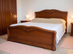 a bed with a wooden frame in a bedroom at Charming apartment in Nughedu Santa Vittoria - 90 m² with fireplace in Nughedu Santa Vittoria