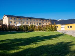 a large building with a large lawn in front of it at Hotel Auto Jas in Nitra