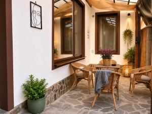 a patio with a table and chairs and windows at Sedra House in Sighişoara