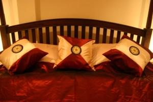 a bed with red and white pillows on it at Tolmaj Family Apartment in Ao Nang Beach