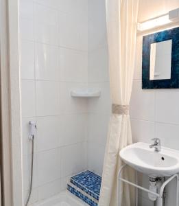 a white bathroom with a sink and a shower at Studio confortable, Rennes les bains, 17 m² + Balcon in Rennes-les-Bains