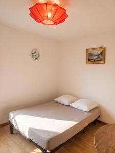 a bed in a room with a clock on the wall at Studio confortable, Rennes les bains, 17 m² + Balcon in Rennes-les-Bains