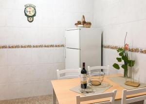 a kitchen with a table with a white refrigerator at Charming house in Teror with garden in Teror