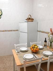 a table with a bowl of fruit and a white refrigerator at Charming house in Teror with garden in Teror +15 photos