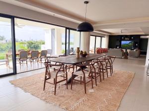 a dining room with a wooden table and chairs at North Island View Family Duplex with private pool by LOV Mauritius in Grande Gaube