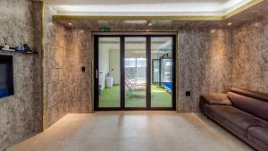 a living room with a couch and a glass door at Chuncheon Poolhouse Epop in Chuncheon +11 photos