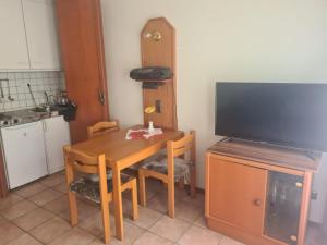 a kitchen with a wooden table and a television at Haus Goldregen - App. 223 in Thalfang