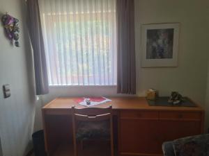 a desk with a chair in front of a window at Haus Goldregen - App. 223 in Thalfang