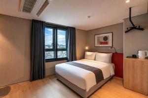 a hotel room with a bed and a large window at Best Western Insadong Hotel in Seoul