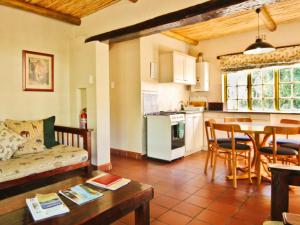 a kitchen and living room with a couch and a table at Rietfontein Guest Farm in Ladismith