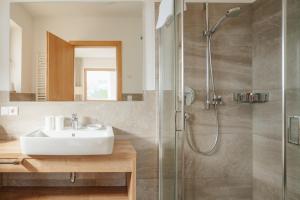 ein Badezimmer mit Waschbecken und Dusche in der Unterkunft Panorama Hotel Flora in Villanders