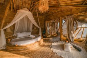a bedroom with a bed in a wooden room at Bamboo Villa with Amazing mount agung view in Selat