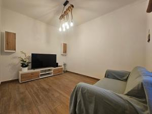 a living room with a couch and a flat screen tv at Casa Saudade Beach House in Zambujeira do Mar