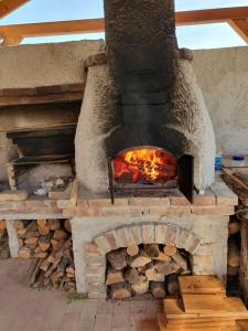 a brick oven with a fire inside of it at Harmónia Aqua Vendégház in Somogysárd