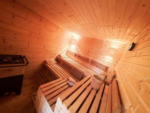 an inside of a wooden sauna with a bucket in it at Harmónia Aqua Vendégház in Somogysárd