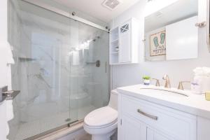 a bathroom with a shower and a toilet and a sink at Sandcastles - Cocoa Beach Oceanfront Condos with Heated Pool Tennis in Cocoa Beach