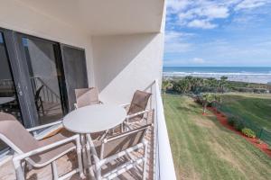 a balcony with a table and chairs and the ocean at Sandcastles - Cocoa Beach Oceanfront Condos with Heated Pool Tennis in Cocoa Beach +61 photos