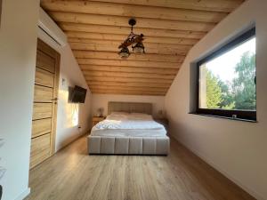 a bedroom with a bed and a ceiling with a window at Relax Chańcza in Pągowiec